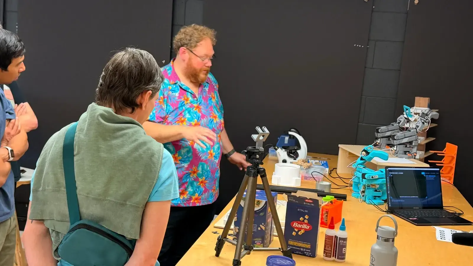Builders gathered around a robot arm demo