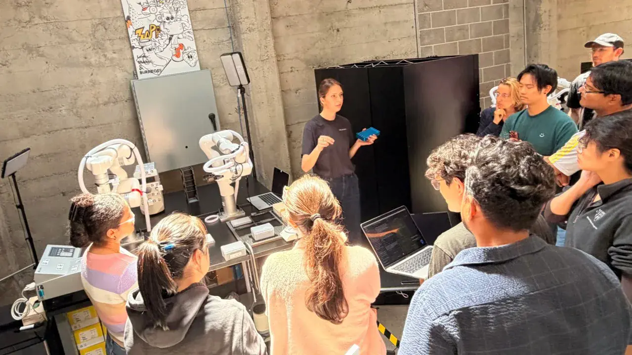 Builders gathered around a robotics demonstration